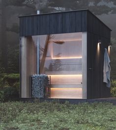 an outdoor sauna in the middle of a field with grass and trees around it