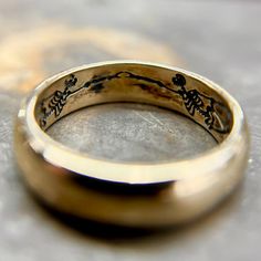 a close up of a gold ring with writing on it