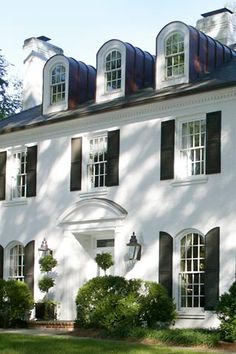 a large white house with black shutters and windows