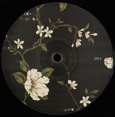 a black disc with white and yellow flowers on it