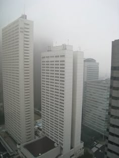 black and white photograph of city buildings in the fog