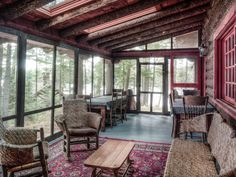 a living room filled with lots of furniture next to a wooden table and chairs on top of a rug