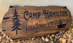 a wooden sign that says camp hamlet, joe's pond tv and campsite