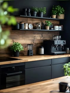 a kitchen with black cabinets and shelves filled with potted plants next to a coffee maker