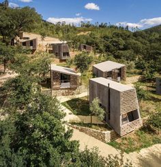 an aerial view of several small houses in the woods