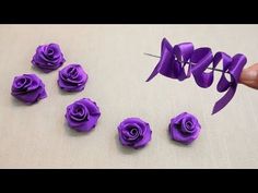 purple paper roses are being made with scissors