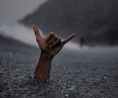 a hand in the water holding up a peace sign