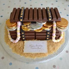 a birthday cake made to look like a chocolate bar with coins on top and a sign that says happy anniversary congratulations