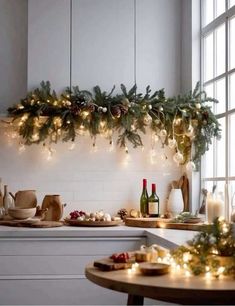 Less is more with modern holiday decor. Christmas Decor Over Cabinets, Kitchen Light Christmas Decor, Christmas Garland In Kitchen, Christmas In The Kitchen Decor, Kitchen Decor Christmas Ideas, Christmas Decor Ideas For Bakery, Christmas Decor Modern House, Green Kitchen Christmas Decor, Diy Christmas Decorations Kitchen