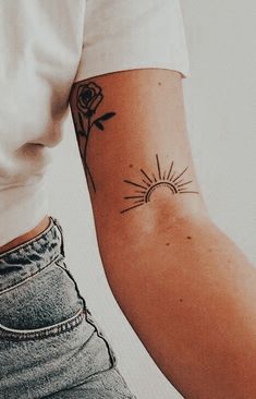 a person with a tattoo on their arm and the sun in the sky behind them