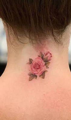 a woman's neck with a small pink rose tattoo on the back of her neck