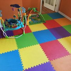 a child's play room with multicolored tiles and toys on the floor