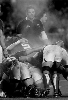 the rugby players are huddled together on the field