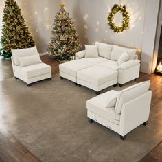 a living room filled with white furniture and christmas trees