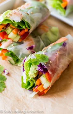 two rolls filled with veggies on top of a cutting board