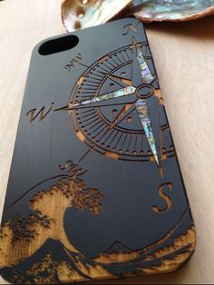 a wooden case with an image of a compass on the front and back cover is sitting on a table