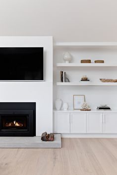 a white living room with a fireplace and entertainment center