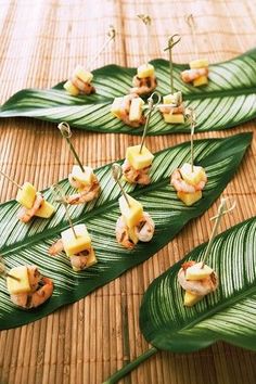 small appetizers are placed on the leaves of a banana leaf, ready to be eaten