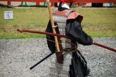 a man dressed in traditional japanese garb holding a bow and arrow