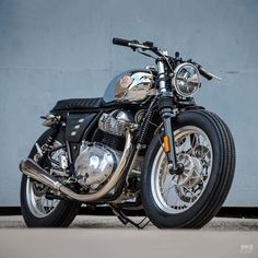 a motorcycle parked in front of a blue wall