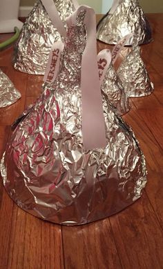 some silver foil wrapped in pink ribbon on a wooden table