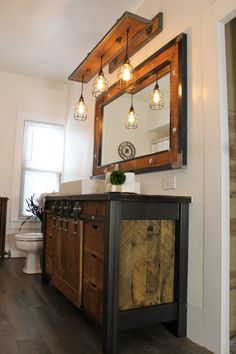 a bathroom with wooden cabinets and lights hanging from the ceiling