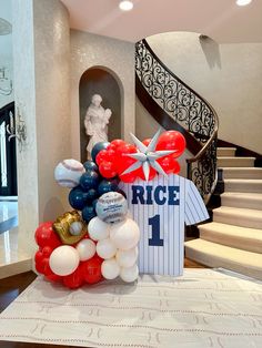 balloons and baseballs are on display in front of a staircase with a sign that reads rice 1