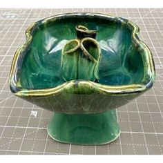 a green bowl with a flower on it