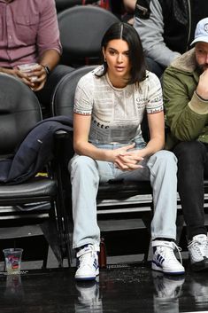 a woman sitting in the stands at a basketball game