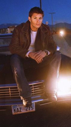 a man sitting on the hood of a car