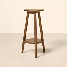 a small wooden stool with a round seat