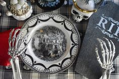 a table topped with plates and silverware next to a book on top of a checkered table cloth