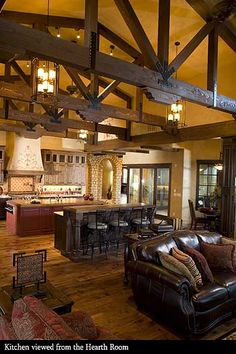 a living room filled with furniture next to a kitchen