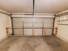 an empty garage with no one inside or outside the door and some shelves on the wall