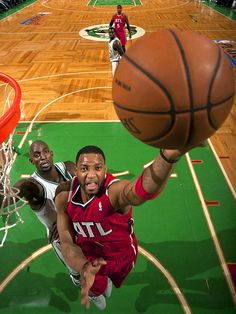 two men playing basketball in an indoor court