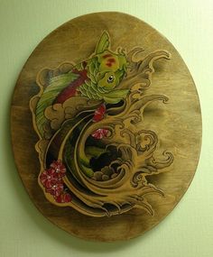 a gold plate with fish and flowers painted on the side, sitting on a wall