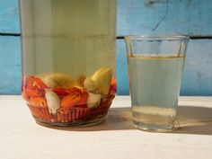 a glass and bottle filled with liquid sitting next to each other on a table top