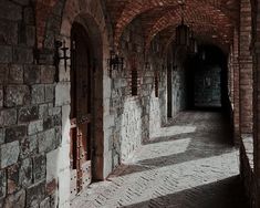 an old brick building with arched doorways and cobblestone walkway between two buildings