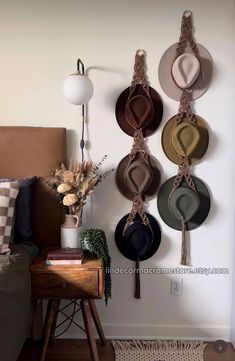 hats are hanging on the wall above a bed