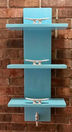 a blue wall mounted shelf with three shelves