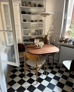 a table and chairs in a room with black and white checkered tile flooring