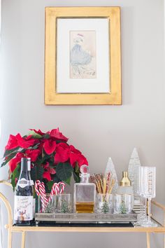 a christmas bar cart with candy canes and poinsettia in the corner