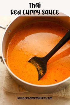 a pot filled with red curry sauce on top of a table