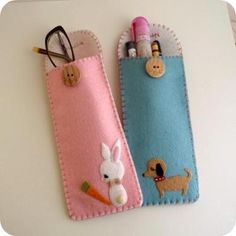 two pencils and pen holders made to look like felt with cartoon animals on them