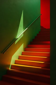 the stairs are red and green in color, with one light shining down on them