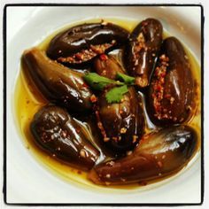 a white plate topped with eggplant covered in sauce