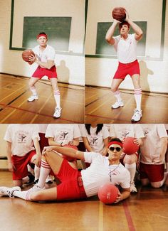 a man in red shorts and white shirt holding a basketball while sitting on the floor