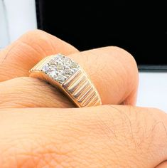 a person's hand with a gold ring on top of it and a diamond in the middle