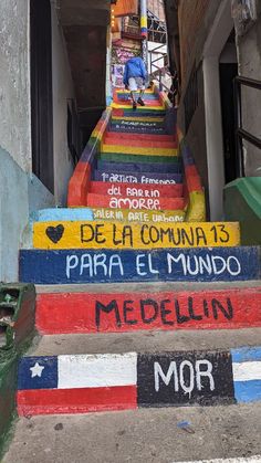 colorful painted steps leading up to the top of a building in an alleyway with graffiti written on them