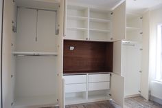 an empty room with white cabinets and wood flooring